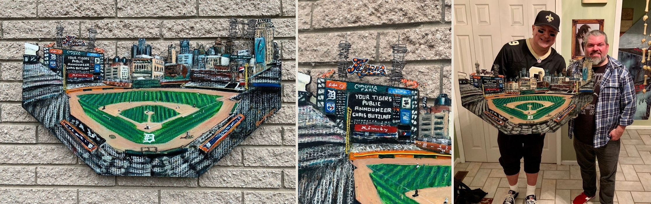 Comerica Park, a hand-cut and hand-painted cardboard relief of the Detroit Tigers ballpark: on a brick wall, a scoreboard close-up, and two friends holding the finished piece