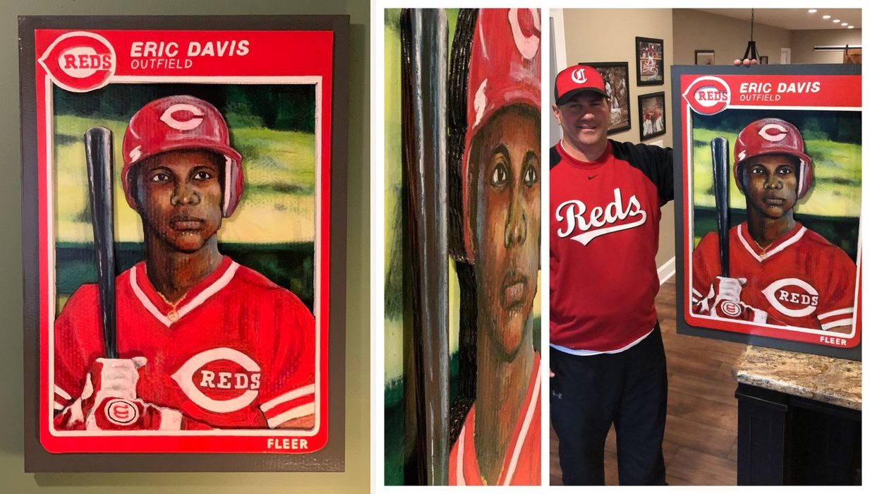 Hand-cut and hand-painted Fleer style baseball card of Cincinnati Reds outfielder Eric Davis in a red helmet holding a bat, on a green wall, and held by the customer at home